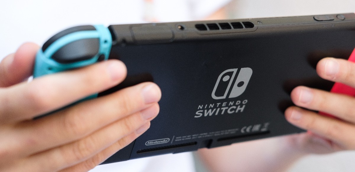 Person hÃ¤lt eine Nintendo Switch in der Hand.