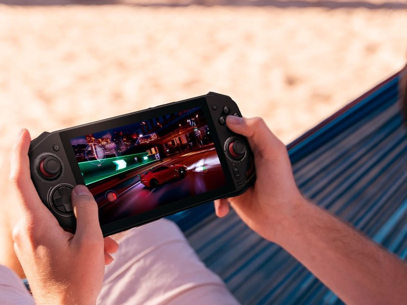 Bild vom Acer Nitro Blade 7. Eine Person spielt am Strand auf dem Handheld ein Spiel.