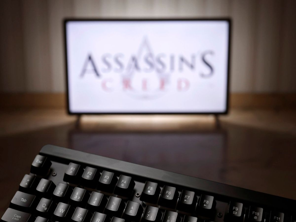 Bildschirm mit Assassin's Creed-Logo und Tastatur im Vordergrund