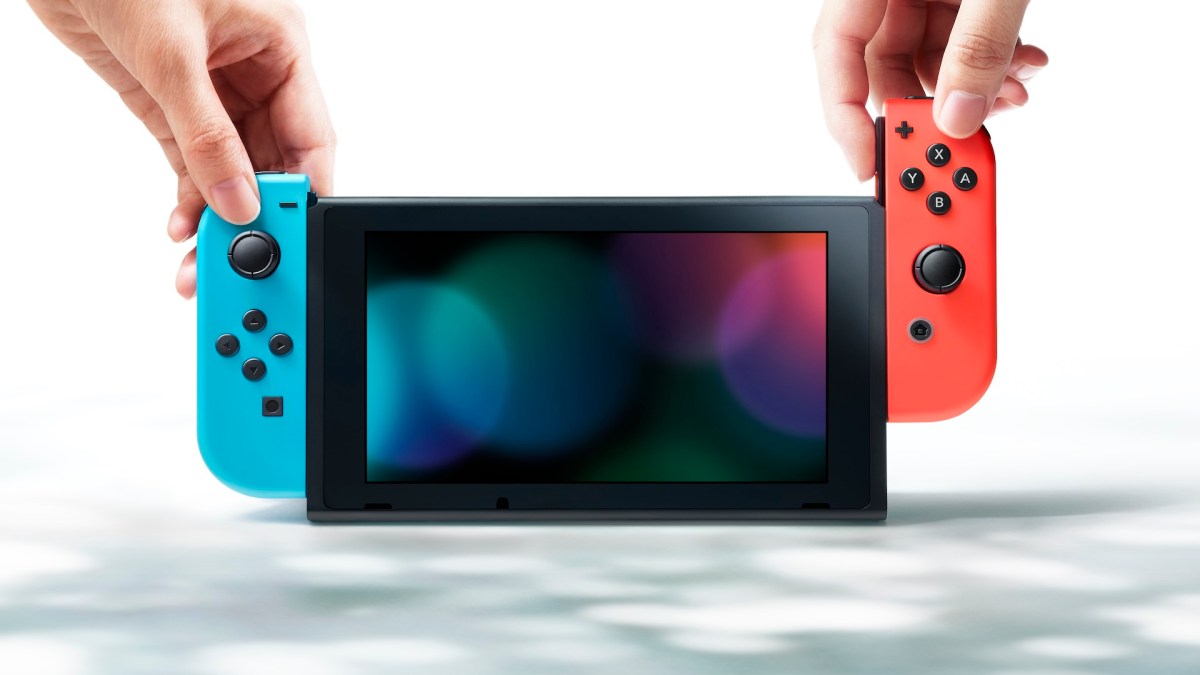 Eine Nintendo Switch mit rotem und blauen Joy-Con sowie zwei HÃ¤nden.