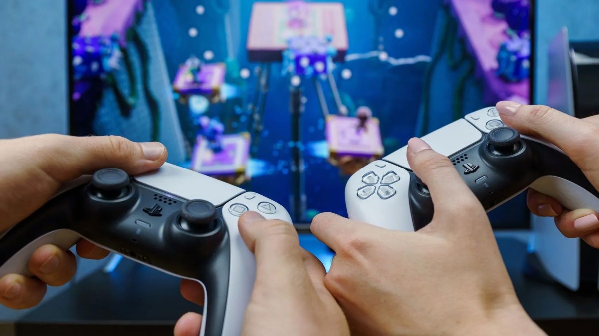 Zwei Personen spielen PS5 mit DualSense-Controllern.
